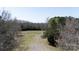 Expansive lot with a mix of cleared area, trees, and driveway access to the open land for potential development at 4229 Motocross Trl, Edgemoor, SC 29712
