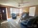 Living room with wood paneled walls, ceiling fan, brick fireplace, and large front window at 514 W Blume St, Landis, NC 28088