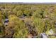 Scenic aerial view of lush tree cover with glimpses of homes and city skyline in the distance at 5215 Milford Rd, Charlotte, NC 28210