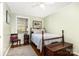 Cozy bedroom with a vintage-style bed, natural light from the window, and hardwood flooring at 5215 Milford Rd, Charlotte, NC 28210
