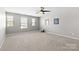 Well-lit bonus room with plush carpeting, ceiling fan, and large windows offering ample natural light at 5827 Eleanor Rigby Rd, Charlotte, NC 28278