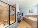 This beautiful bathroom offers a walk-in shower, a soaking tub, and tiled floor at 7240 Baybrooke Ln, Harrisburg, NC 28075