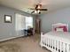 A well-lit bedroom shows a desk, a bed, and white sheer curtains for a peaceful ambiance at 7240 Baybrooke Ln, Harrisburg, NC 28075