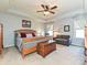 Spacious bedroom with tray ceiling, wooden bed, cozy sofa, and natural lighting from the window at 7240 Baybrooke Ln, Harrisburg, NC 28075