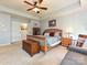 Bright bedroom with a wooden bed frame, ceiling fan, and ample closet space for storage at 7240 Baybrooke Ln, Harrisburg, NC 28075