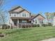 Inviting home exterior with a well-manicured lawn, covered porch, and an American flag on display at 7240 Baybrooke Ln, Harrisburg, NC 28075
