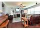 Cozy living room with fireplace, ceiling fan, leather furniture, and a bright window view at 7240 Baybrooke Ln, Harrisburg, NC 28075