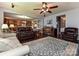Bright open living room with wood floors, ceiling fan, and an open floor plan to the kitchen and dining area at 7240 Baybrooke Ln, Harrisburg, NC 28075