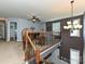 Loft area with wooden railings, ceiling fan, elegant chandelier, and natural lighting at 7240 Baybrooke Ln, Harrisburg, NC 28075
