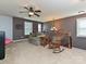 Well-lit loft area with ceiling fan, neutral carpet, comfortable seating, and staircase access at 7240 Baybrooke Ln, Harrisburg, NC 28075