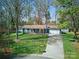Charming single-story home with a well-manicured front lawn and a paved driveway leading to an attached garage at 7656 Eastbourne Rd, Charlotte, NC 28227