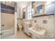 Cozy bathroom featuring a classic pedestal sink, a window for natural light, and vintage design elements at 8425 E Franklin St, Mount Pleasant, NC 28124