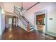 Inviting entryway featuring staircase, hardwood floors, chandelier, and a glimpse of the living room fireplace at 8425 E Franklin St, Mount Pleasant, NC 28124