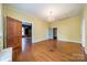 Sunlit living room with hardwood floors, vintage chandelier and doors that frame the view of the house interior at 8425 E Franklin St, Mount Pleasant, NC 28124