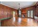 Spacious living room with wood-paneled walls, hardwood floors, fireplace, and classic ceiling fan at 8425 E Franklin St, Mount Pleasant, NC 28124