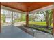 Quaint side porch featuring brick columns, a stained wood ceiling, and access to the well-manicured backyard at 8425 E Franklin St, Mount Pleasant, NC 28124