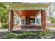 Cozy side porch with brick columns, wood ceiling, and a glimpse of the home's exterior details at 8425 E Franklin St, Mount Pleasant, NC 28124
