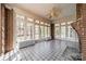 Bright sunroom with tiled floors, brick accents, a ceiling fan, and multiple windows at 8425 E Franklin St, Mount Pleasant, NC 28124