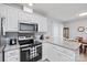 Bright eat-in kitchen featuring granite countertops, white cabinets, and stainless appliances at 8801 Oldenburg Dr, Mount Pleasant, NC 28124