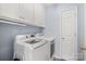 Bright laundry room featuring white washer and dryer with ample overhead cabinet space at 8801 Oldenburg Dr, Mount Pleasant, NC 28124