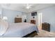 Large main bedroom with neutral decor, a tray ceiling, TV and views of other rooms at 8801 Oldenburg Dr, Mount Pleasant, NC 28124