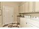 Well-equipped laundry room with cabinetry, granite counters, sink and checkerboard flooring at 9703 Cotton Stand Rd, Charlotte, NC 28277