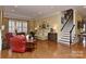 Spacious living room with hardwood floors, a fireplace, and stairs, perfect for Gathering gatherings and entertaining guests at 9703 Cotton Stand Rd, Charlotte, NC 28277