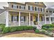 Welcoming front porch with white columns, rocking chairs, and lush landscaping for relaxing and enjoying the outdoors at 9703 Cotton Stand Rd, Charlotte, NC 28277