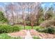 Well-maintained backyard with a stone pathway leading to lush landscaping and mature trees at 1027 Brookline Dr, Huntersville, NC 28078