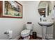 Charming powder room with pedestal sink, oval mirror, artwork, and hardwood flooring at 1027 Brookline Dr, Huntersville, NC 28078