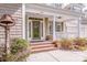 Covered front porch with brick steps, white columns, and a stained-glass front door at 1027 Brookline Dr, Huntersville, NC 28078