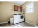 Bright laundry room features a washer, dryer, storage cabinets, and a window for natural light at 1027 Brookline Dr, Huntersville, NC 28078