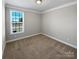 A well-lit bedroom features neutral walls, carpeted floors, and a window with exterior view at 111 Canada Dr, Statesville, NC 28677