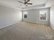 An empty bedroom features carpet floors, two windows, a ceiling fan, and bright neutral-colored walls at 111 Canada Dr, Statesville, NC 28677