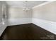 A dining room features dark wood floors, chair rail molding, bright neutral-colored walls, and a chandelier at 111 Canada Dr, Statesville, NC 28677