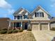 Charming two-story home featuring stone accents, a covered front porch, and an attached two-car garage at 111 Canada Dr, Statesville, NC 28677