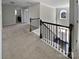 A bright hallway features neutral walls, carpeted floors, and a staircase with dark wood railings and white risers at 111 Canada Dr, Statesville, NC 28677