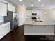 A modern kitchen features granite countertops, white cabinets, stainless steel appliances, and dark wood floors at 111 Canada Dr, Statesville, NC 28677