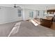 Bright living room featuring a ceiling fan, neutral walls, multiple windows, and sliding glass doors to the backyard at 1300 Lena St, Monroe, NC 28112