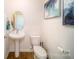 Charming powder room featuring a pedestal sink, toilet, and decorative artwork at 133 Calvin Creek Dr, Troutman, NC 28166