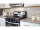 Close-up of modern range, tile backsplash, granite countertops and white cabinets in the kitchen at 133 Calvin Creek Dr, Troutman, NC 28166