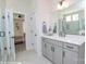 Bathroom featuring a sink with gray cabinets, large mirror, shower, and doorway to a bedroom at 2011 Mantle Ridge Dr # 193, Wesley Chapel, NC 28079