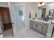 Bathroom featuring a sink with gray cabinets, a large mirror, and an open doorway at 2011 Mantle Ridge Dr # 193, Wesley Chapel, NC 28079