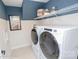 Modern laundry room with front loading washer and dryer and overhead shelving at 2011 Mantle Ridge Dr # 193, Wesley Chapel, NC 28079