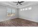 A spacious bedroom featuring modern ceiling fan, trim, windows, and wood-look flooring at 2063 Fordhill St, Rock Hill, SC 29732