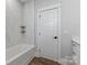 Elegant bathroom showcasing a soaking tub with marble tile surround and minimalist shelving at 2078 Fordhill St, Rock Hill, SC 29732