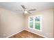 Bright bedroom features wood-look flooring, a modern ceiling fan, and a large window providing natural light at 3001 Austin Chaney Rd, Monroe, NC 28110