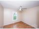 This cozy bedroom features wood-look flooring, a ceiling fan, and a large window offering natural light at 3001 Austin Chaney Rd, Monroe, NC 28110