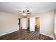 A spacious bedroom with wood-look floors featuring a ceiling fan, closet, and views into other rooms at 3001 Austin Chaney Rd, Monroe, NC 28110