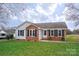 Charming single-story home featuring a brick facade, black shutters, and a well-maintained front lawn at 3001 Austin Chaney Rd, Monroe, NC 28110